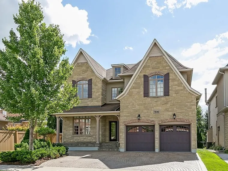 Two-storey stone detached home with steep gables, a covered front porch and a double garage on an interlock driveway at 1510 Arrowhead Rd, Oakville, ON